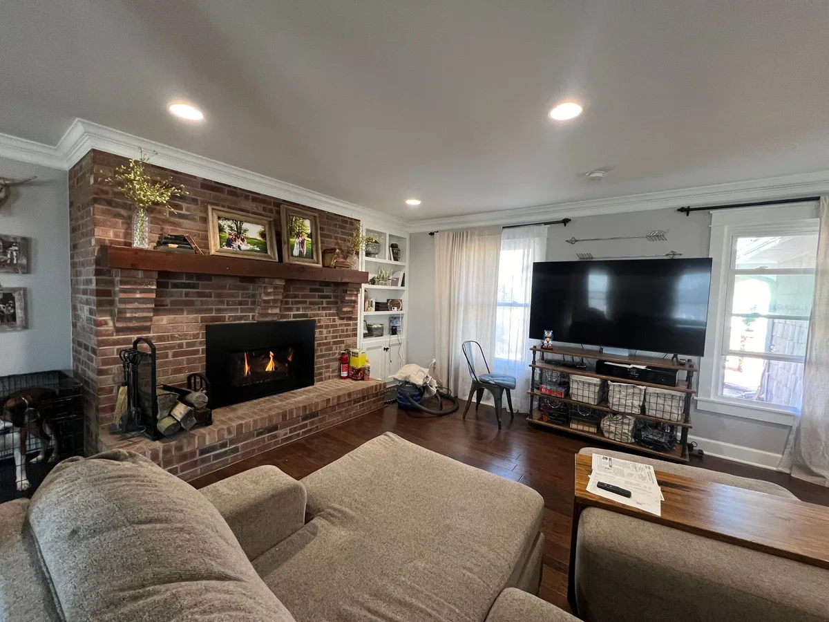 A direct-vent gas insert burning in a brick fireplace wall